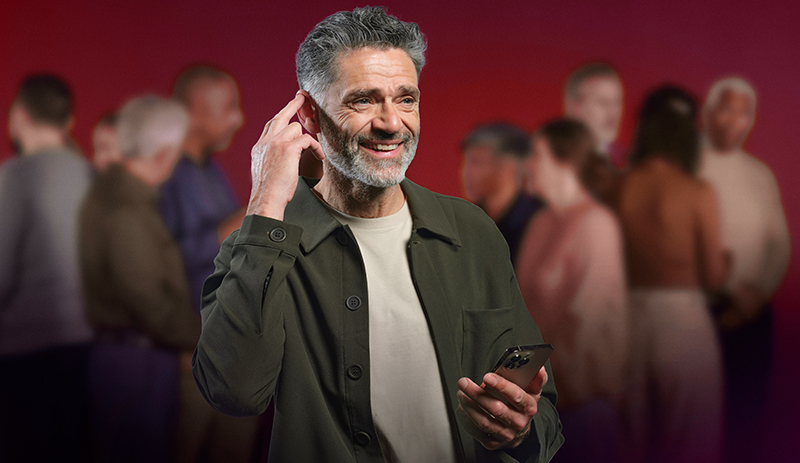 Mann steuert Hörgerät über Smartphone-App