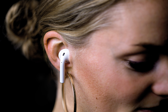 Frau trägt Kopfhörer mit SNUG Otoplastiken